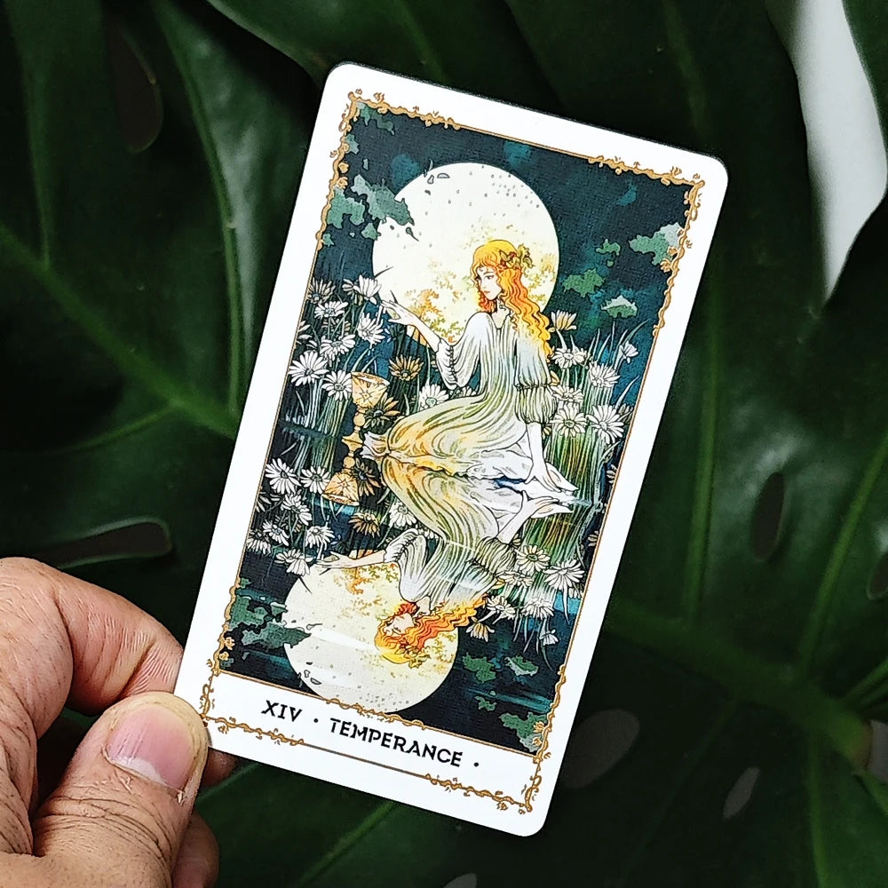 Silent Desolate Tarot — XIV Temperance card: golden-haired figure in white dress pouring water by moonlight in a field of white flowers, gold ornate border