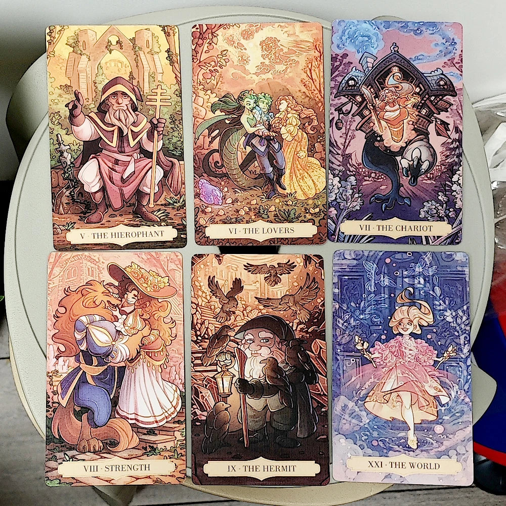 Once Upon a Time Tarot — six Major Arcana: V The Hierophant (hooded elder with cross-staff), VI The Lovers (fairy and dragon in enchanted garden), VII The Chariot (gnome on snail-drawn mechanical chariot), VIII Strength (flame-haired witch with sleeping beast), IX The Hermit (elder with lantern and ravens), XXI The World (dancer in pink tulle amid blue floral swirls)