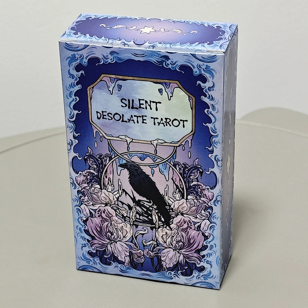 Silent Desolate Tarot blue art nouveau box featuring a raven perched among white peonies beneath the dripping title plaque ‘Silent Desolate Tarot’ on a cerulean wave-patterned background
