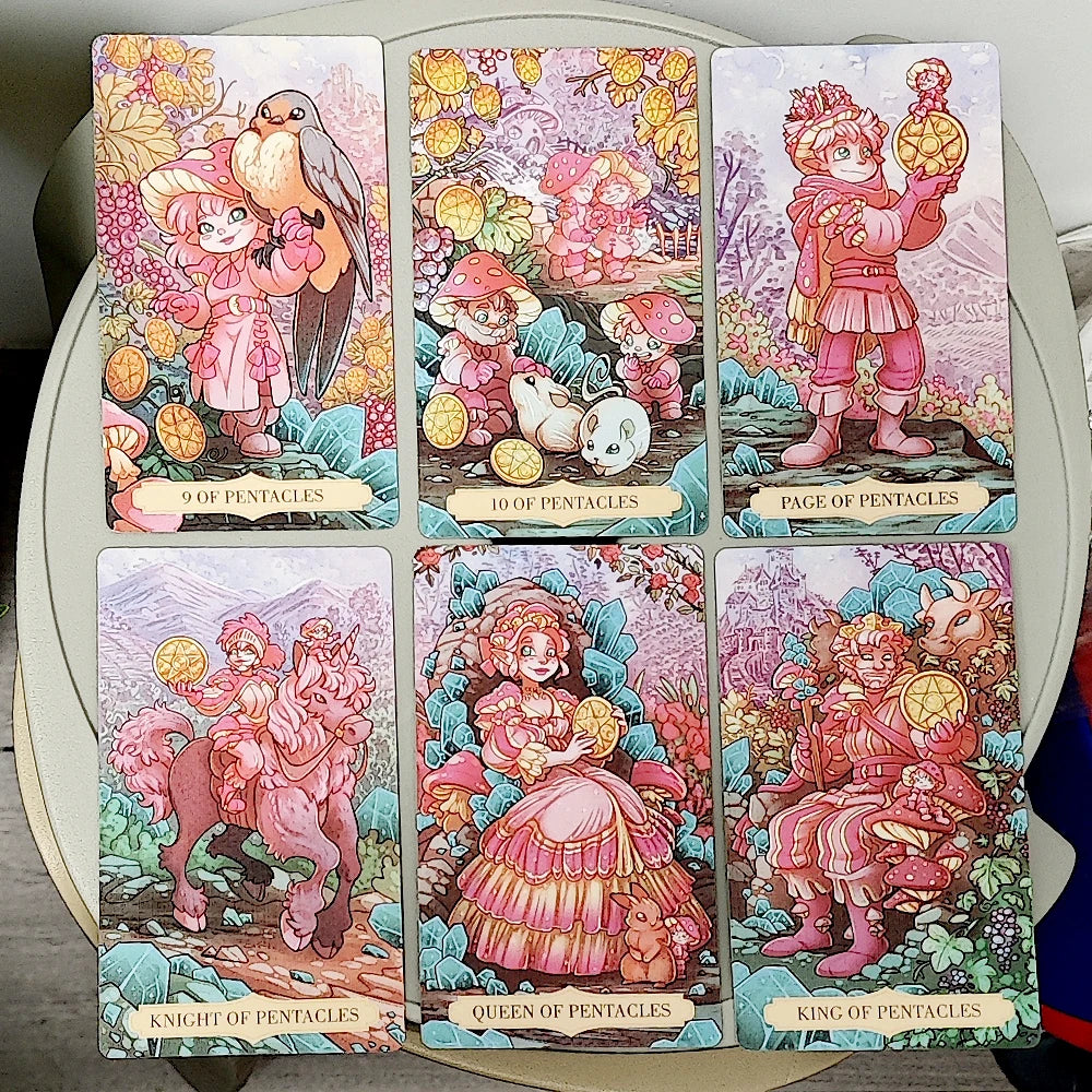 Once Upon a Time Tarot — six Pentacles court cards: 9 of Pentacles (pink-clad girl with a robin), 10 of Pentacles (gnomes with mushrooms and a white bunny), Page of Pentacles (adventurer holding a gold pentacle coin), Knight of Pentacles (rider on a woolly pink horse), Queen of Pentacles (fairy queen in pink ball gown amid teal crystals), King of Pentacles (goblin king with antlered deer)