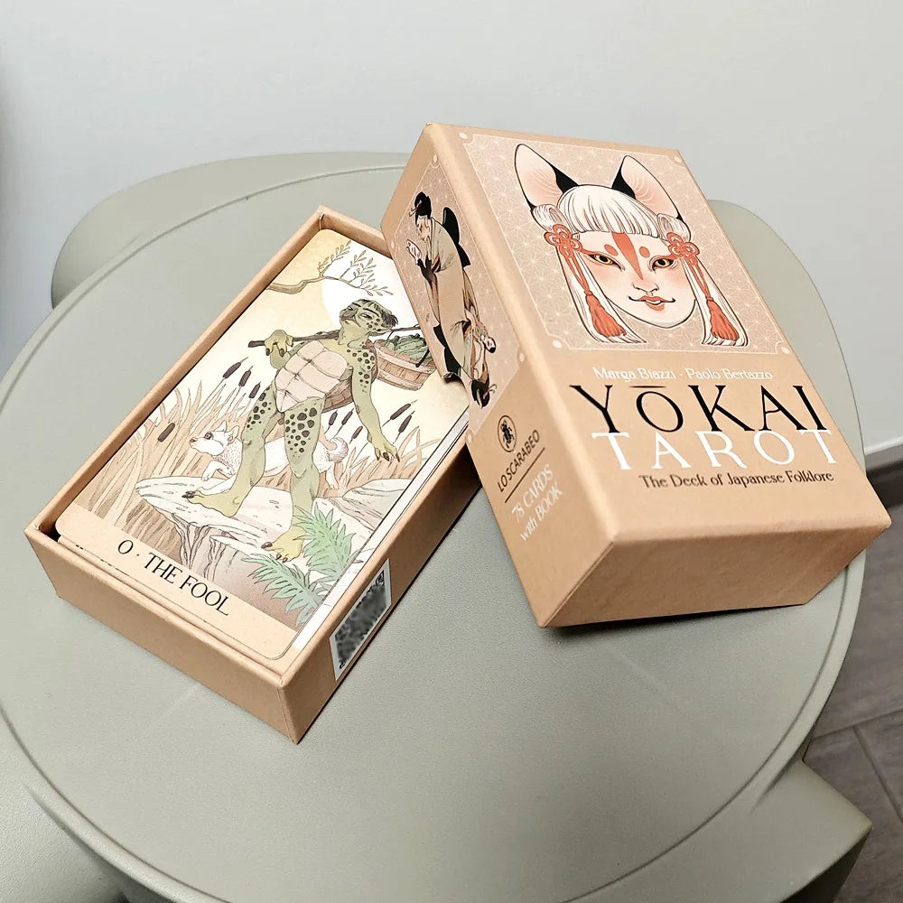 Yōkai Tarot cards spread out showing The Devil, Knight of Swords, Ace of Coins and card backs with floral pattern